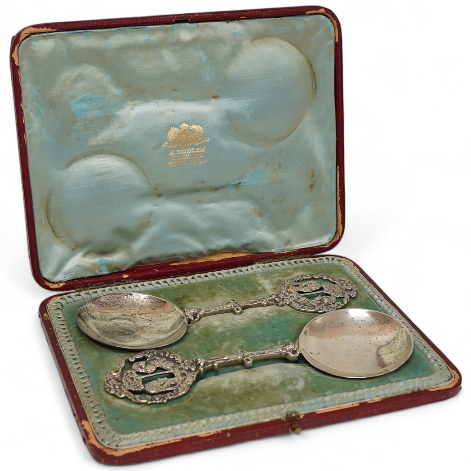 A cased pair of late Victorian silver spoons, the pierced terminals decorated with the busts of a lady and gentleman, James Dudley, London, 1898/1900, 19cm, 5.2oz.